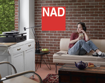 A woman listening to music on NAD turntable and NAD amp